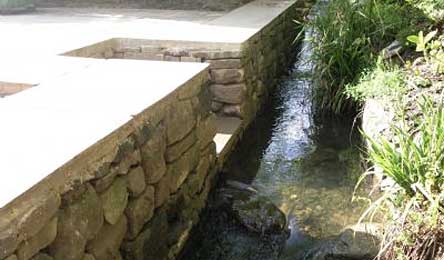 Dry stone retaining wall by stream